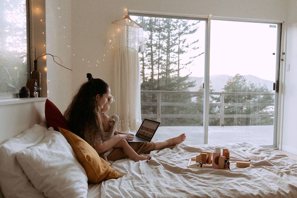 mother with small daughter surfing laptop