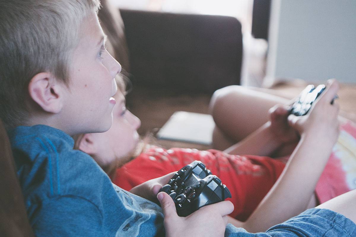 two boy and girl holding game controllers