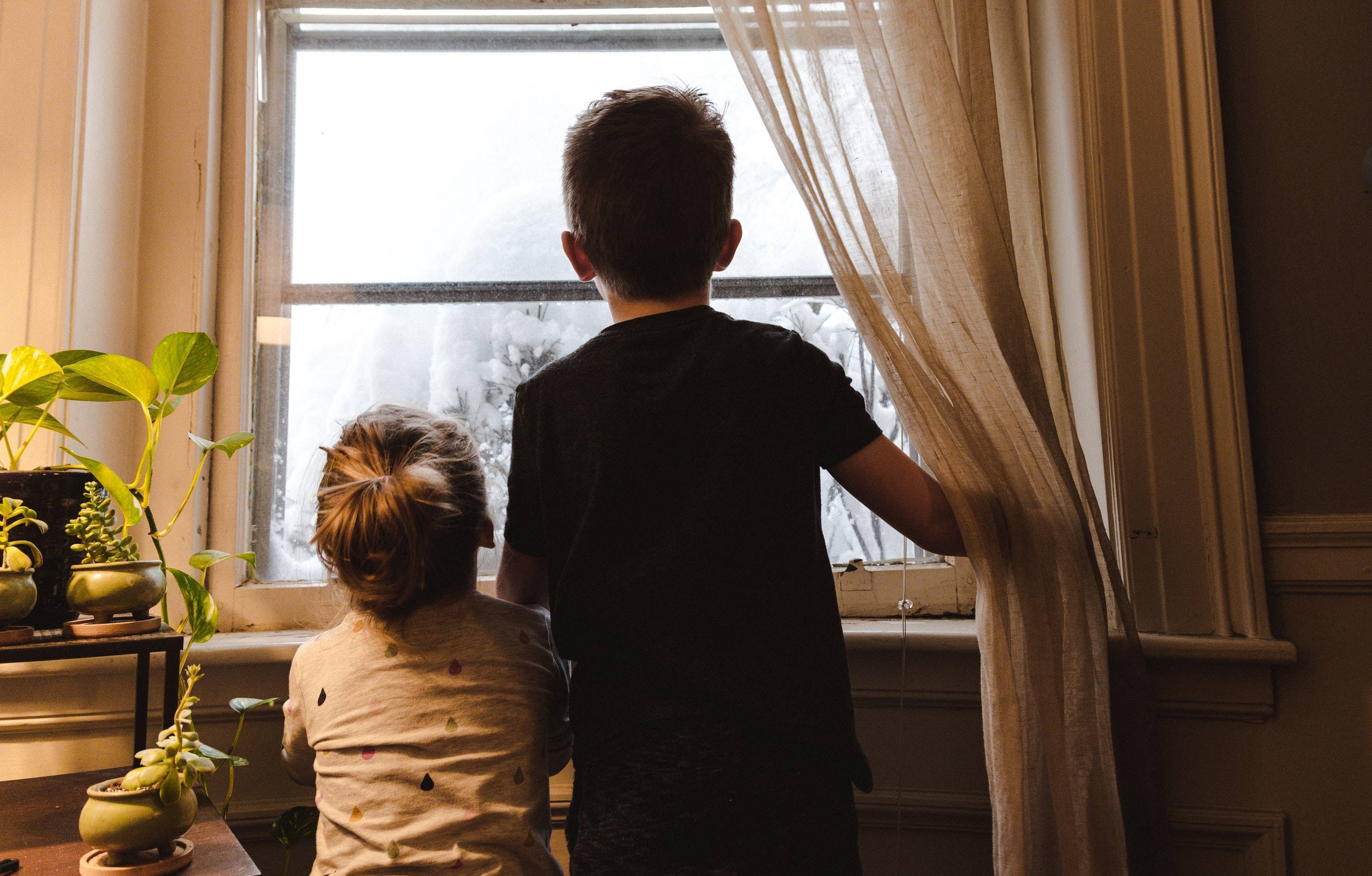 Children looking outer view from inside room