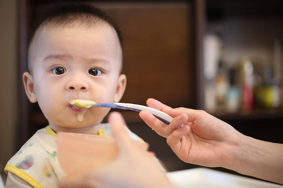 Mother feeding food to baby child