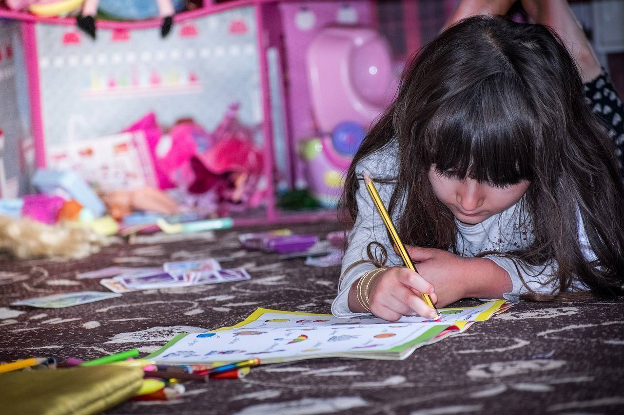 Girl coloring on children book