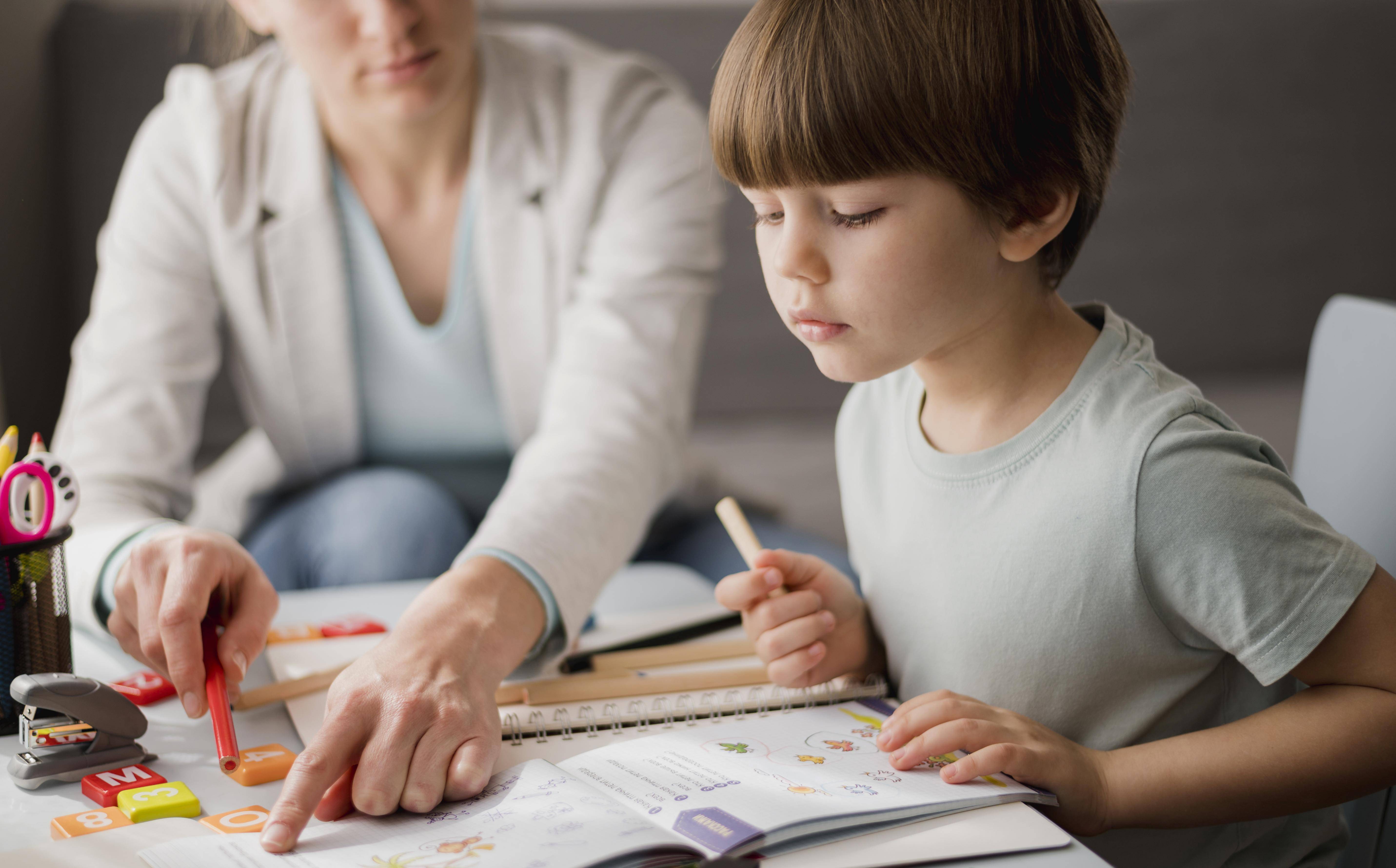 Tutor teaching boy child
