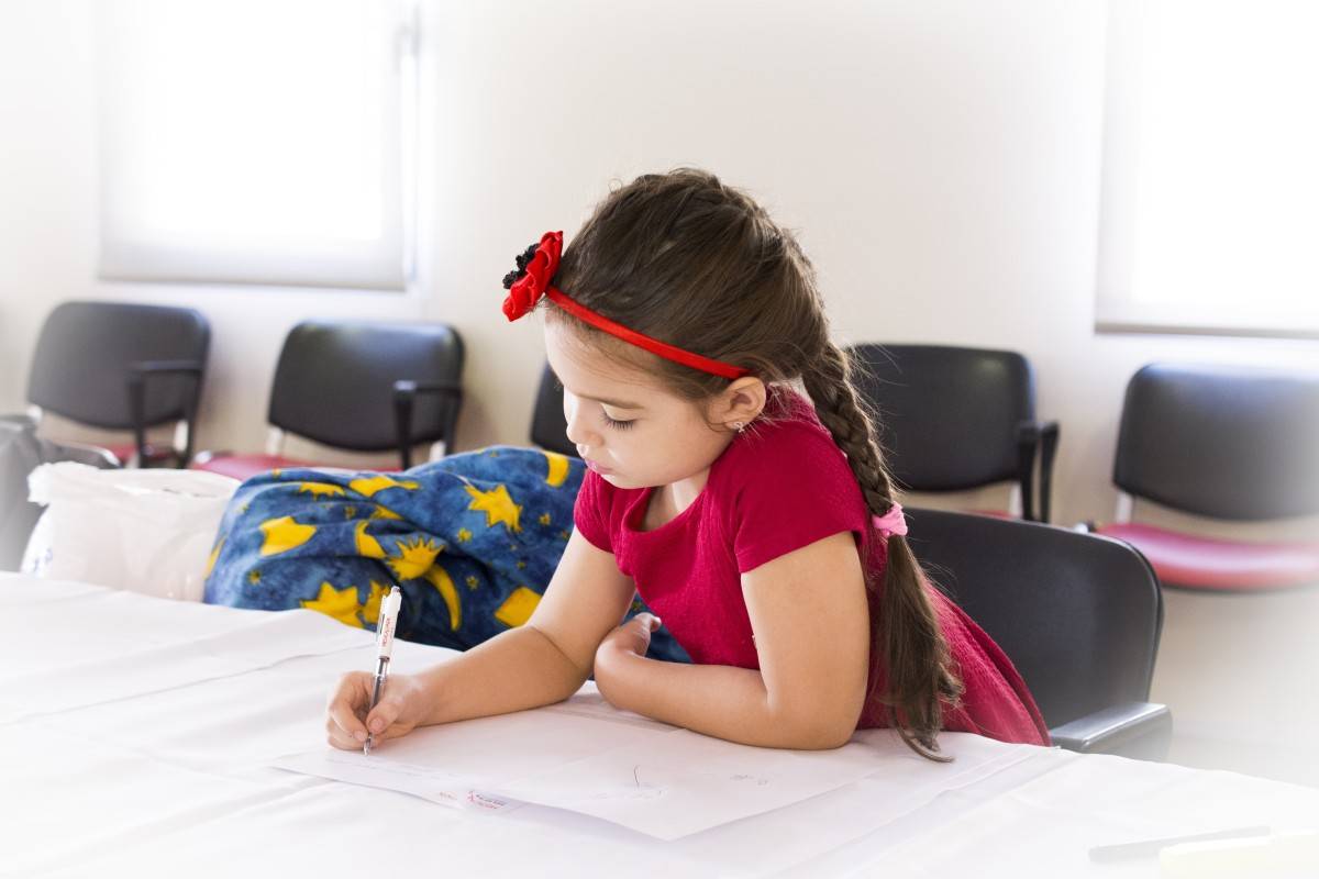 Girl child writing on a book