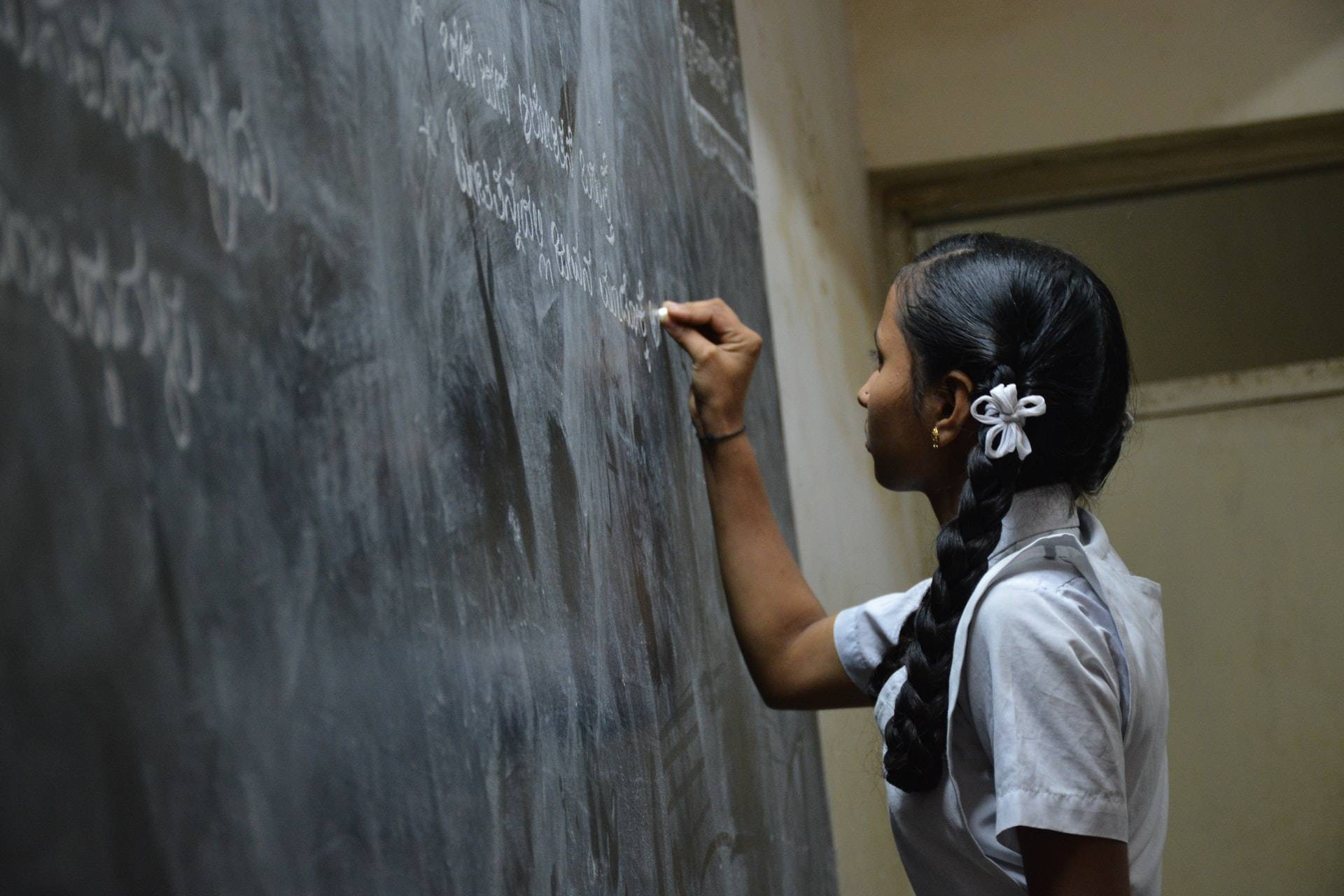 Girl writing on a blackboard