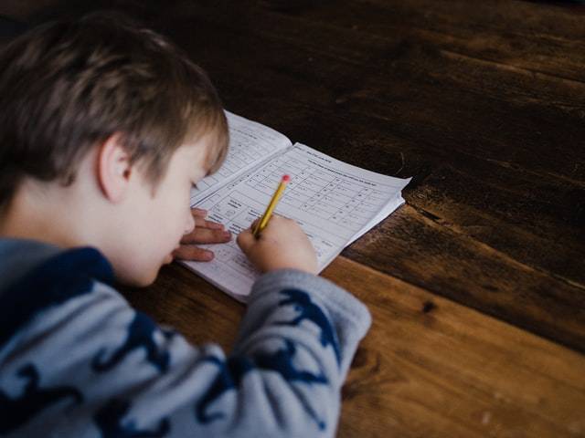 Boy Child Writing on a Book