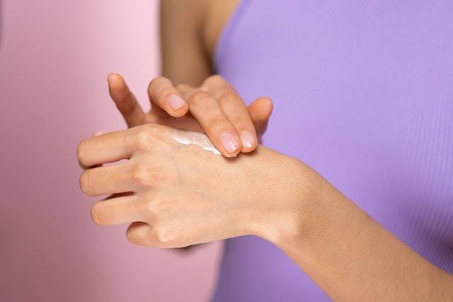 Applying Skincare Cream on Hand
