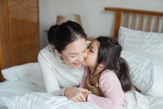 Mom Kissing Daughter